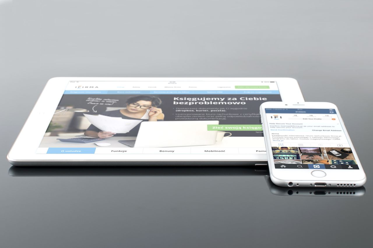 gallery-05 Une tablette moderne et un smartphone affichant du contenu web sur une surface réfléchissante, mettant en avant la technologie et la connectivité.
